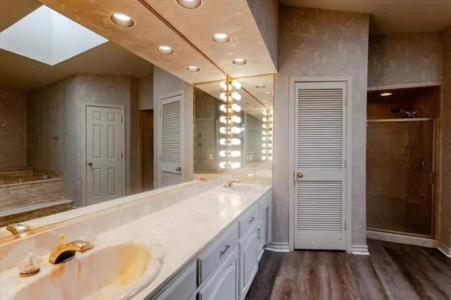 a kitchen with stainless steel appliances granite countertop a sink a stove cabinets counter space and wooden floor