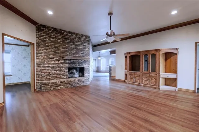 a view of a livingroom with wooden floor and a fireplace