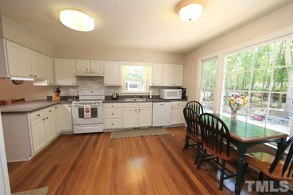 1295 Pilot-Riley Road Zebulon, NC 27597 - Photo 5 of 18 a large kitchen with cabinets wooden floor and stainless steel appliances