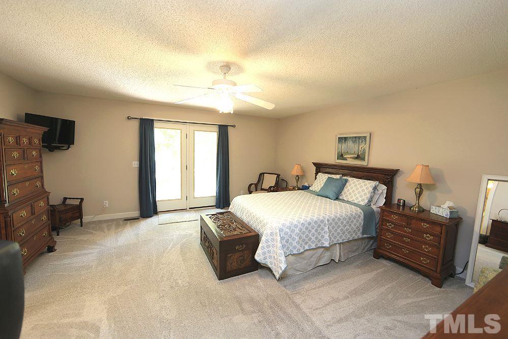 1295 Pilot-Riley Road Zebulon, NC 27597 - Photo 6 of 18 a spacious bedroom with a bed a couch and large windows