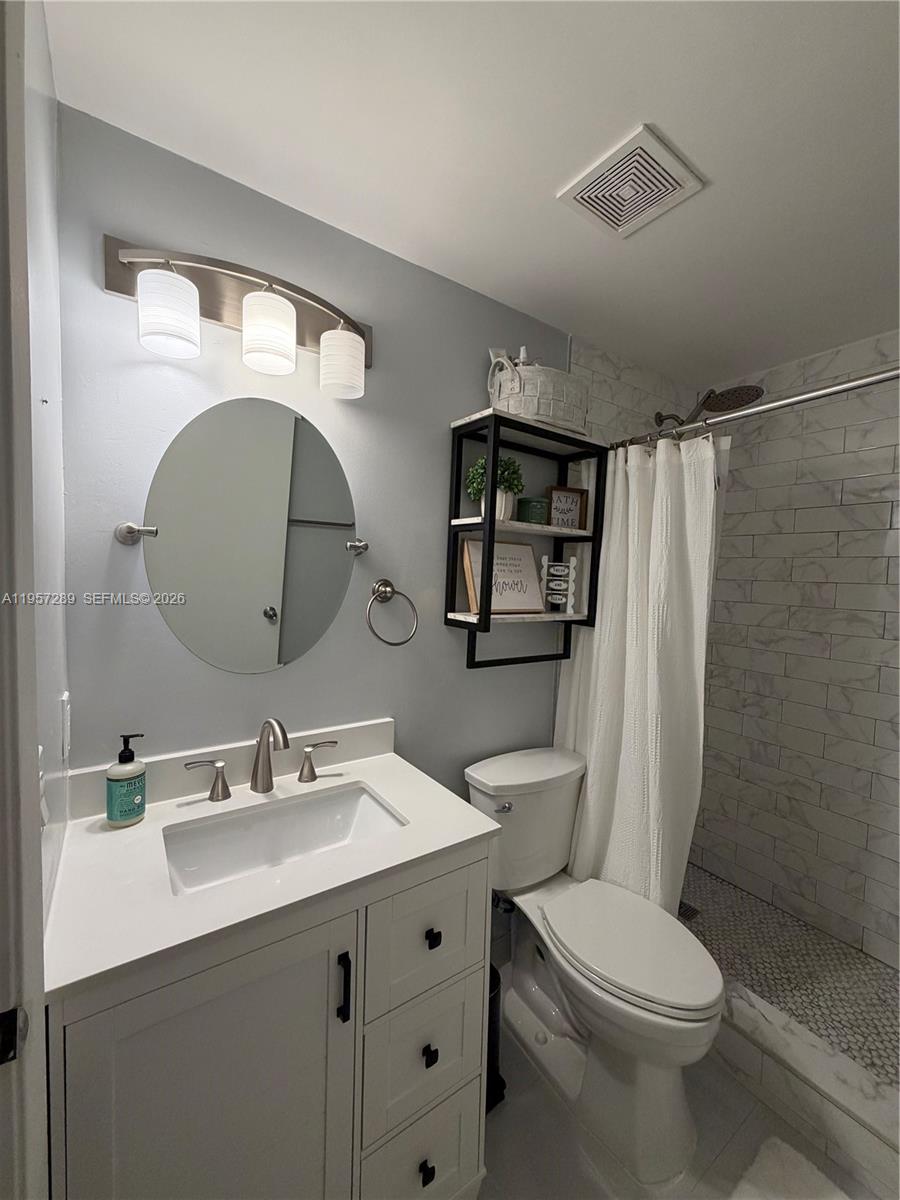 8260 Southwest 149th Court, Unit 9204 Miami, FL 33193 - Photo 15 of 25 a bathroom with a sink vanity mirror and toilet
