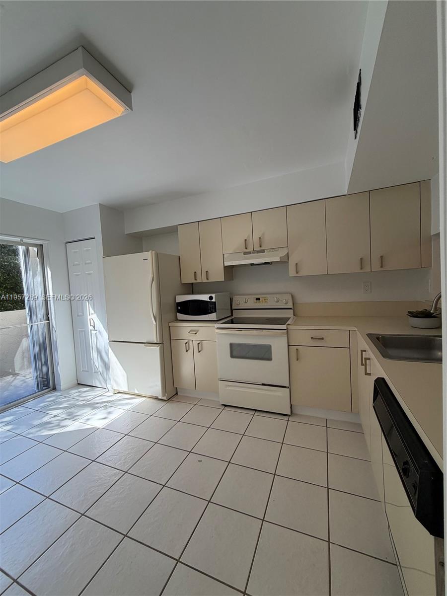 8260 Southwest 149th Court, Unit 9204 Miami, FL 33193 - Photo 7 of 25 a kitchen with cabinets and appliances