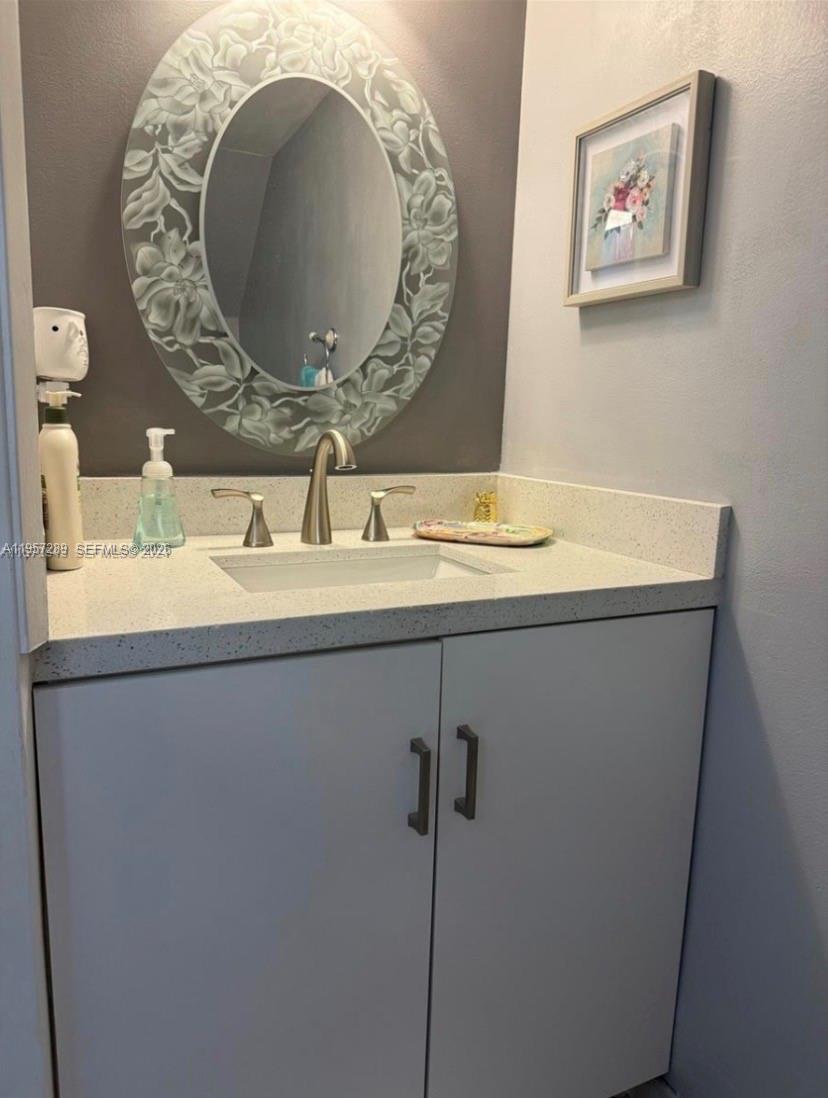 8260 Southwest 149th Court, Unit 9204 Miami, FL 33193 - Photo 10 of 25 a bathroom with a granite countertop sink a mirror and vanity