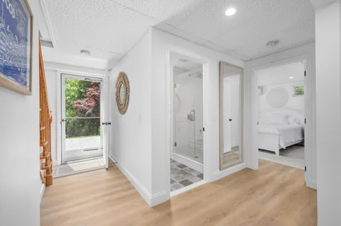 a view of a hallway with bathroom and wooden floor