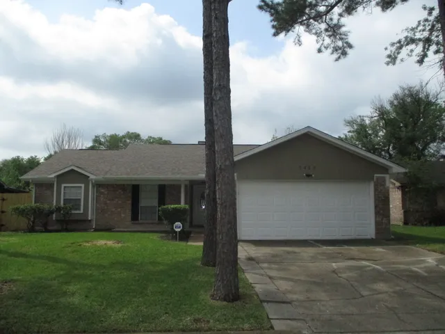 a front view of a house with a garden and yard