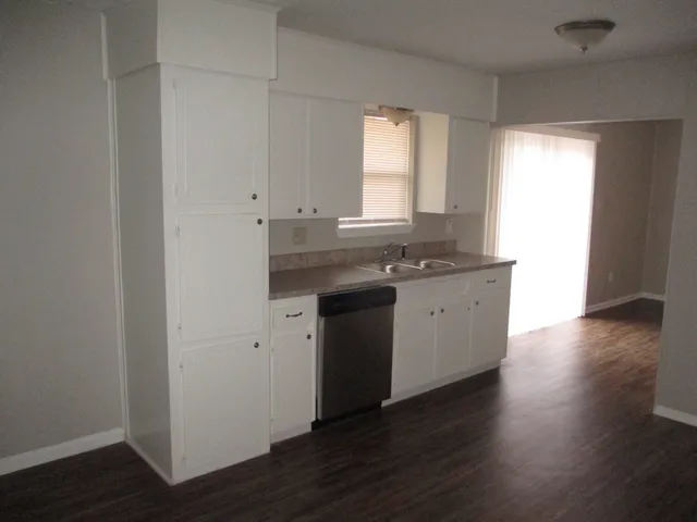 a kitchen with a sink cabinets and wooden floor