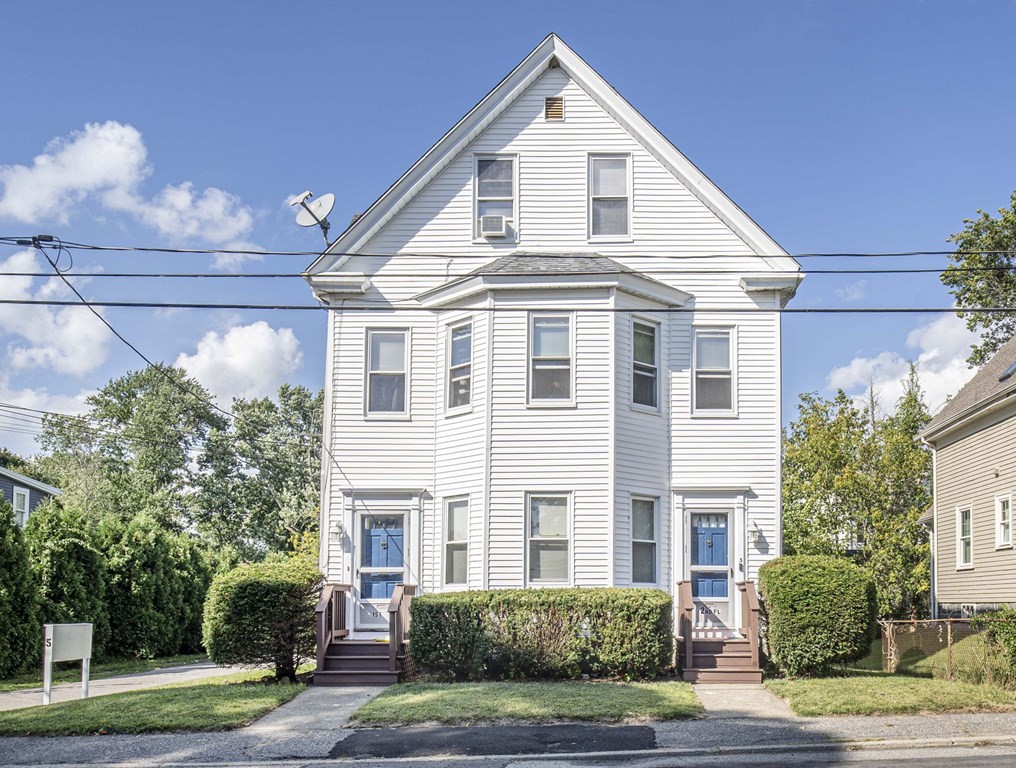a view of a white building among the street with palm trees
