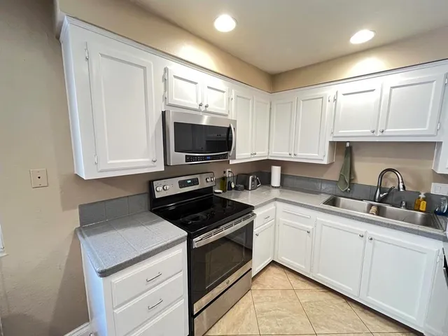 a kitchen with stainless steel appliances a stove sink and cabinets