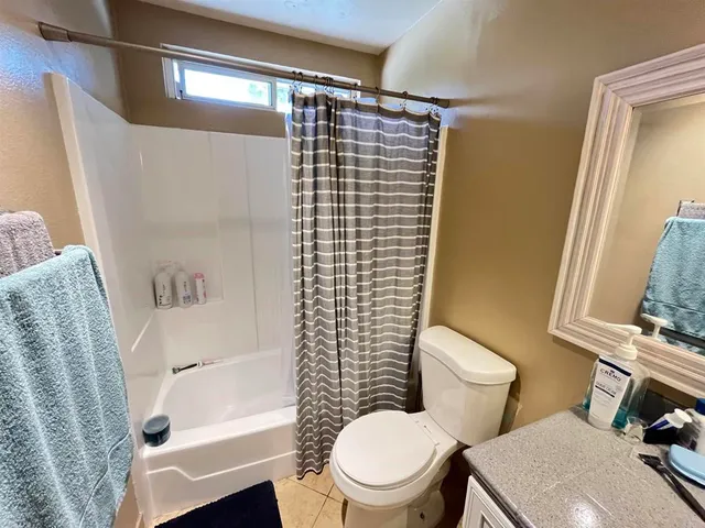 a white toilet sitting next to a bathroom sink and tub