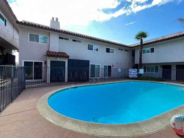 a view of a house with swimming pool and a chairs in patio