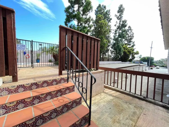 a balcony with street view with wooden floor and fence