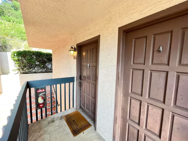 a view of a porch with a door and wooden floor