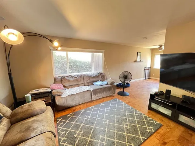 a living room with furniture a flat screen tv and a large window