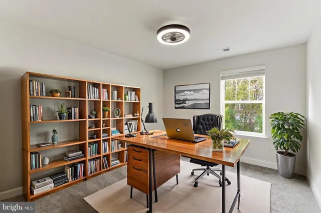 a view of a workspace with a bookshelf and a window