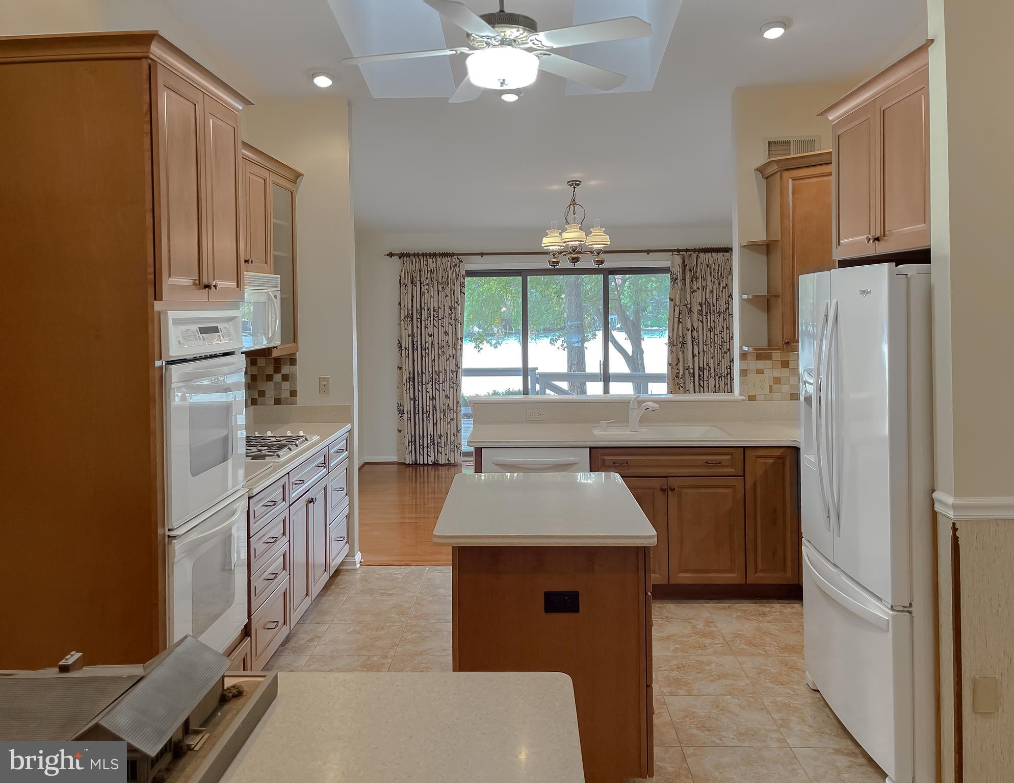44973 Smiths Nursery Road Hollywood, MD 20636 - Photo 71 of 111 a kitchen with stainless steel appliances granite countertop a refrigerator a sink dishwasher a stove a dining table and chairs with wooden floor