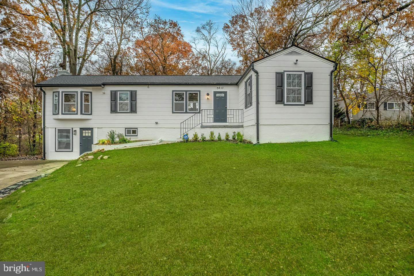 a front view of a house with a yard and trees