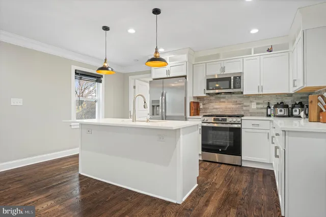 a kitchen with stainless steel appliances granite countertop a stove top oven microwave and cabinets