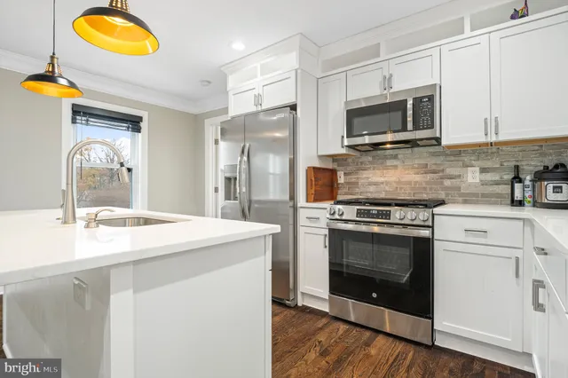 a kitchen with white cabinets and stainless steel appliances