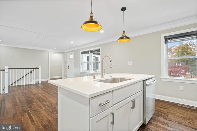 a kitchen with a sink a center island a stove and a window
