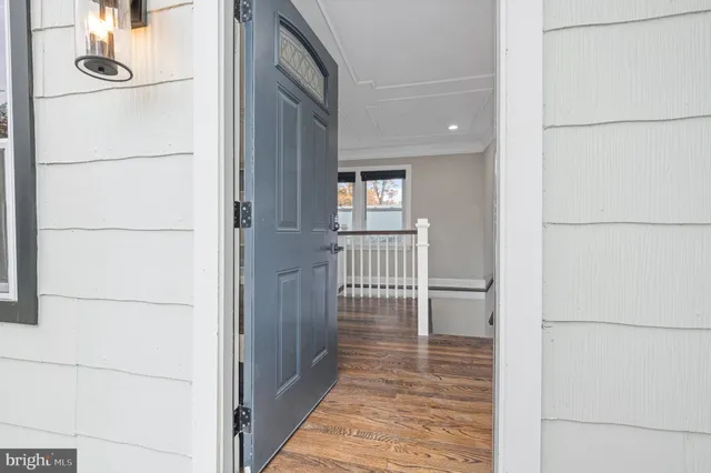a view of a hallway with wooden floor and glass door