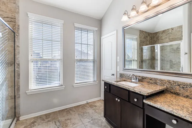 an empty room with chandelier fan and windows