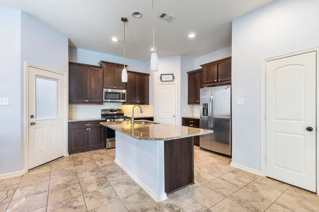 a living room with furniture kitchen view and a window