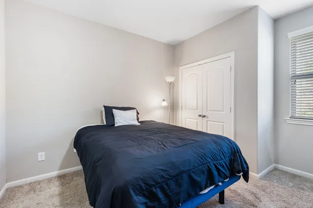 an empty room with chandelier fan and windows