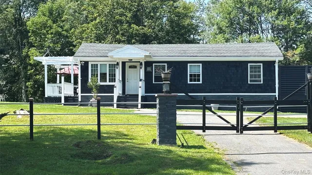 a view of house with a big yard and sitting area