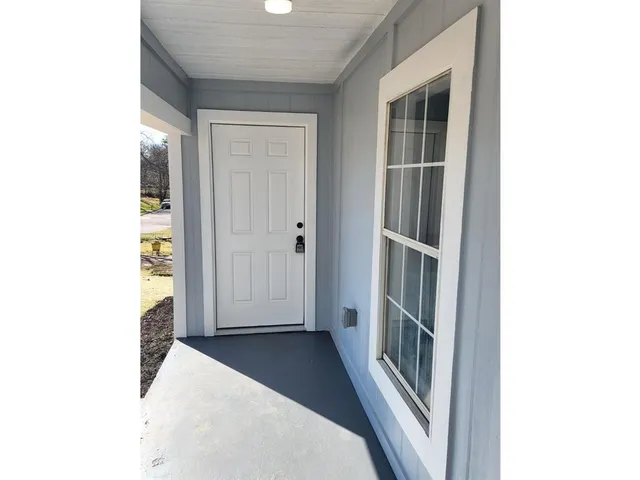 a view of a hallway with wooden floor and entryway