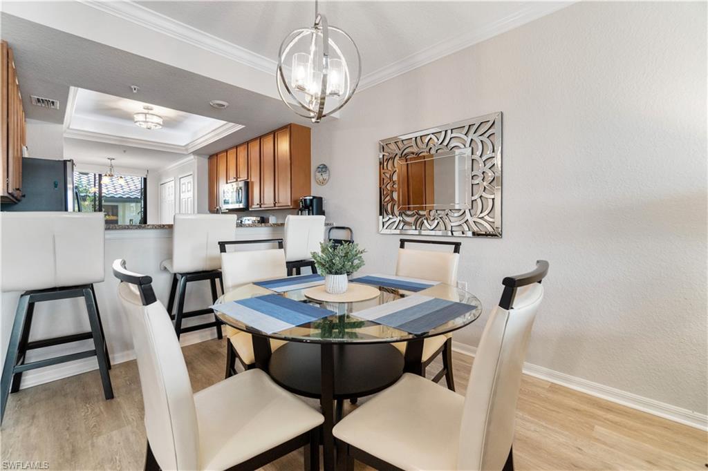 9525 Avellino Way, Unit 2615 Naples, FL 34113 - Photo 6 of 16 a view of a dining room with furniture window and wooden floor