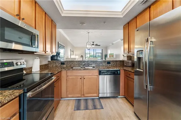 a kitchen with stainless steel appliances granite countertop a stove a sink and a refrigerator