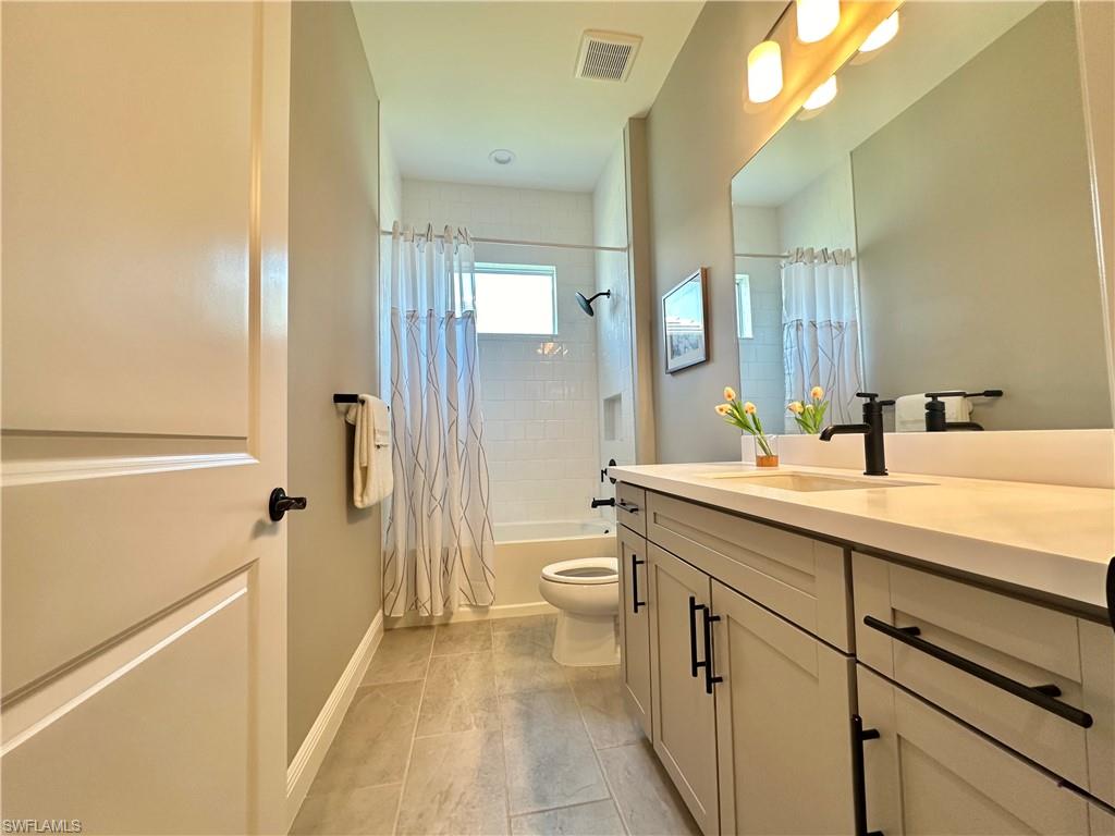 3998 Perseus Street Naples, FL 34120 - Photo 11 of 26 Bathroom featuring shower / bath combination with curtain and vanity