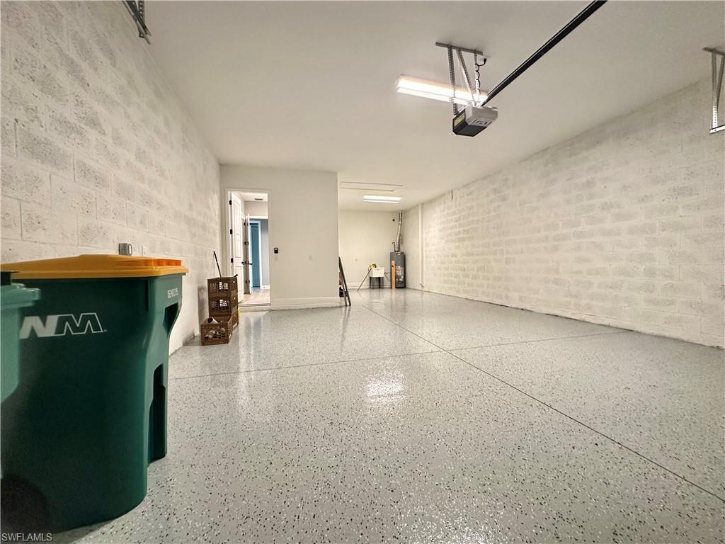 3998 Perseus Street Naples, FL 34120 - Photo 16 of 26 Garage featuring concrete block wall, water heater, and a garage door opener