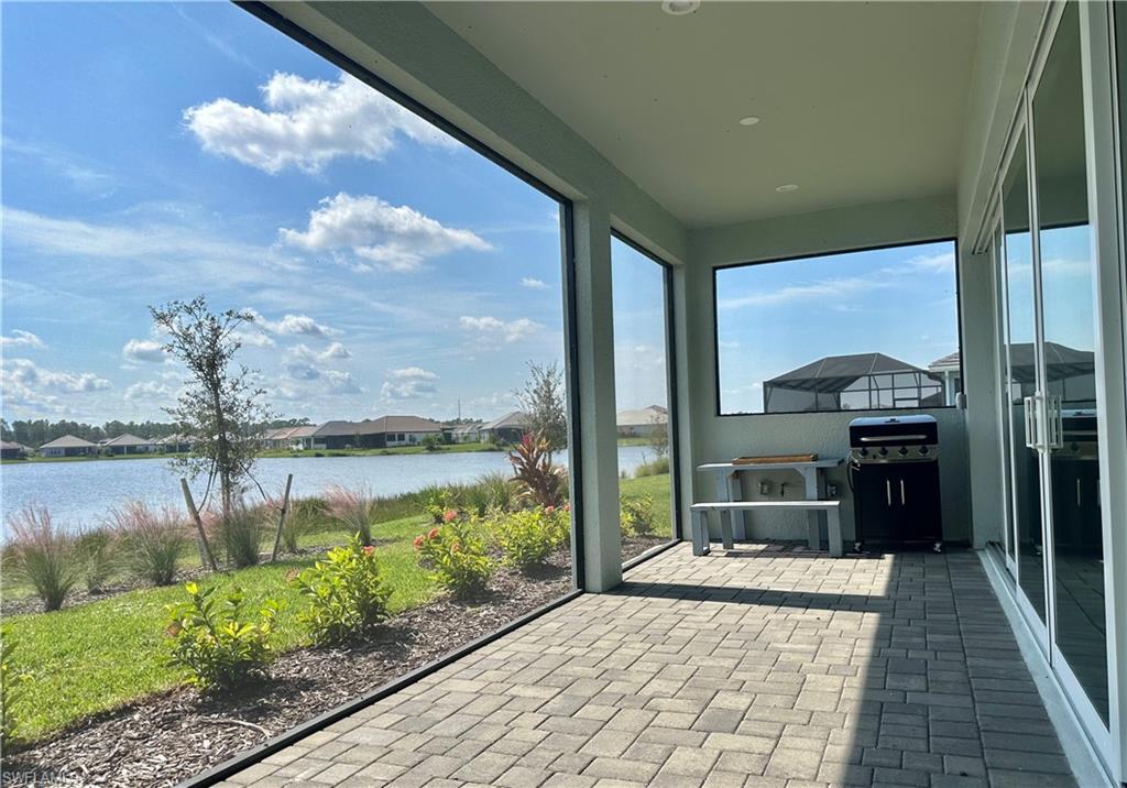 3998 Perseus Street Naples, FL 34120 - Photo 18 of 26 Unfurnished sunroom with a residential view, brick patterned floors, and a water view