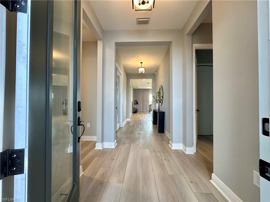 3998 Perseus Street Naples, FL 34120 - Photo 2 of 26 Hallway with light wood-type flooring and baseboards