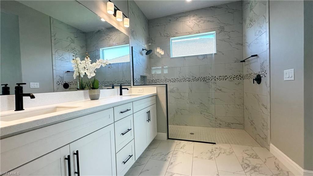 3998 Perseus Street Naples, FL 34120 - Photo 9 of 26 Full bath featuring double vanity, a walk in shower, and light marble finish flooring