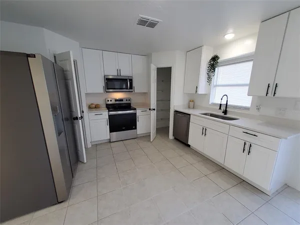 a kitchen with stainless steel appliances granite countertop a refrigerator sink and stove