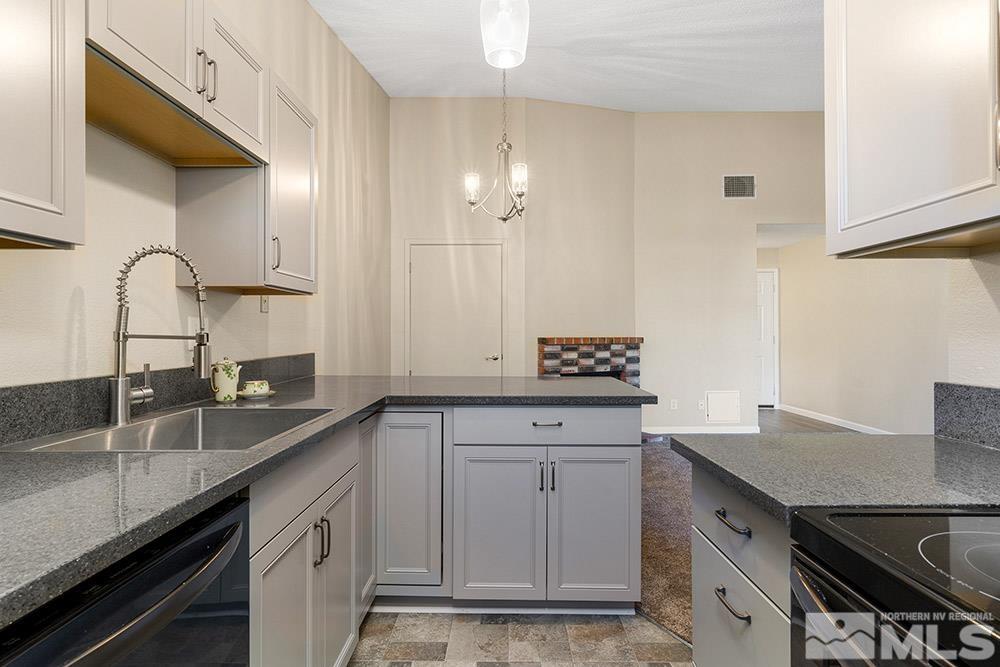 4386 Matich Drive Reno, NV 89502 - Photo 7 of 20 a kitchen with granite countertop a sink a stove and cabinets