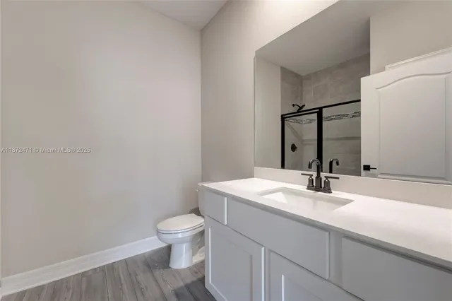 a bathroom with a granite countertop sink toilet and mirror