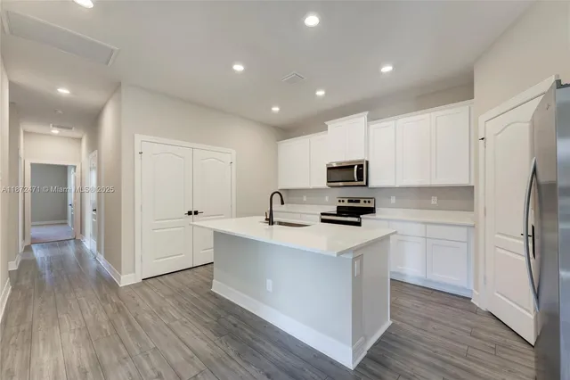 a kitchen with white cabinets and stainless steel appliances