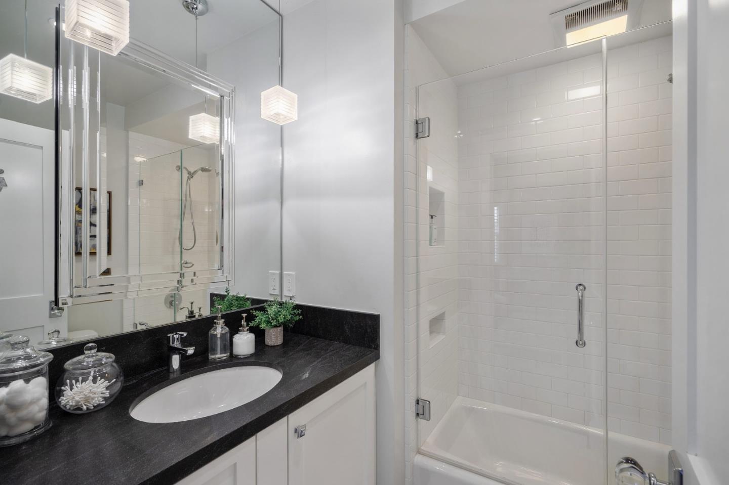 910 Sunset Drive San Carlos, CA 94070 - Photo 30 of 62 a bathroom with a granite countertop sink a shower and a mirror