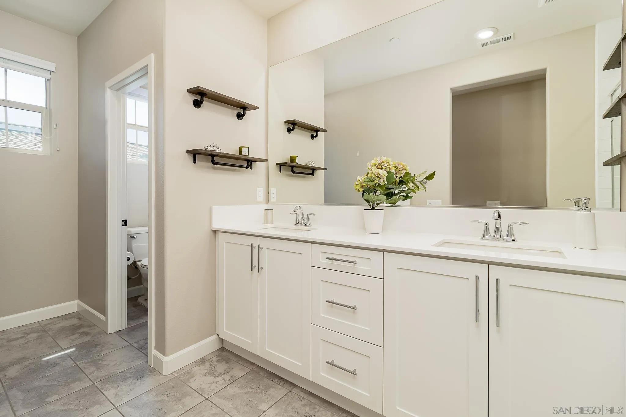 1094 Delpy View Point Vista, CA 92084 - Photo 16 of 43 a bathroom with a double vanity sink a mirror and shower
