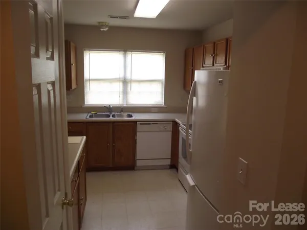 a kitchen with a sink a refrigerator and window