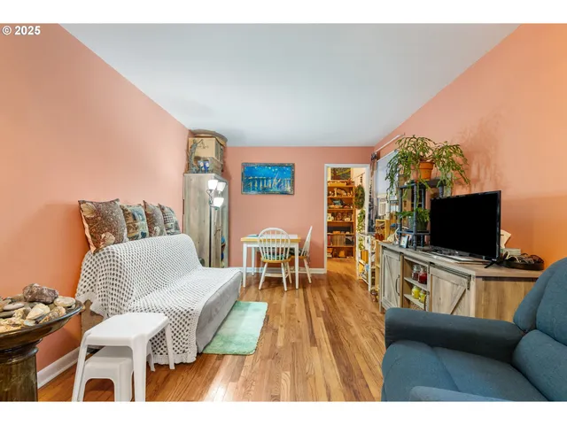 a living room with stainless steel appliances kitchen island granite countertop furniture and a wooden floor