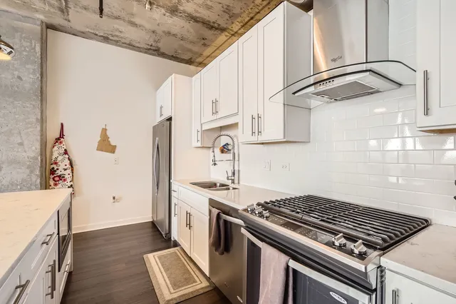 a kitchen with stainless steel appliances granite countertop a stove and a refrigerator