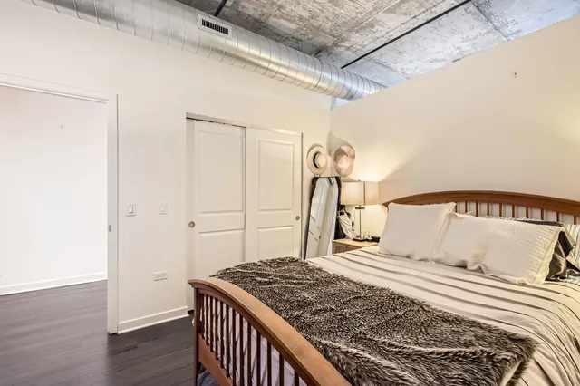 a bedroom with a large bed and wooden floor
