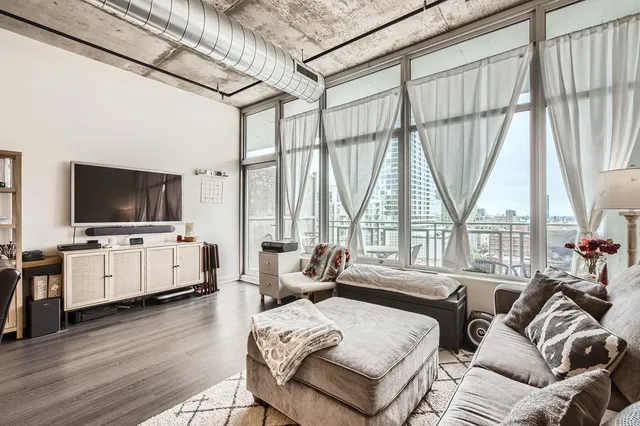 a living room with furniture a flat screen tv and a large window