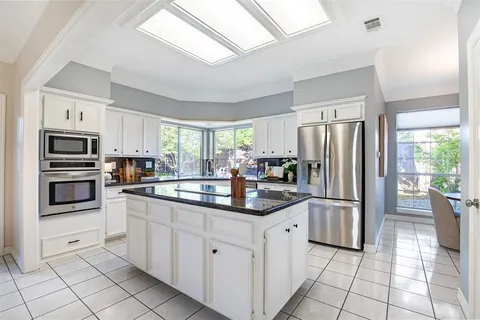 a kitchen with stainless steel appliances granite countertop a refrigerator and a sink