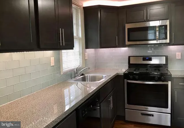 a kitchen with stainless steel appliances wooden cabinets and a sink
