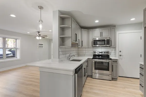 a kitchen with kitchen island granite countertop a sink stainless steel appliances and cabinets
